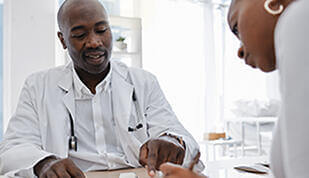 Patient signing document with doctor